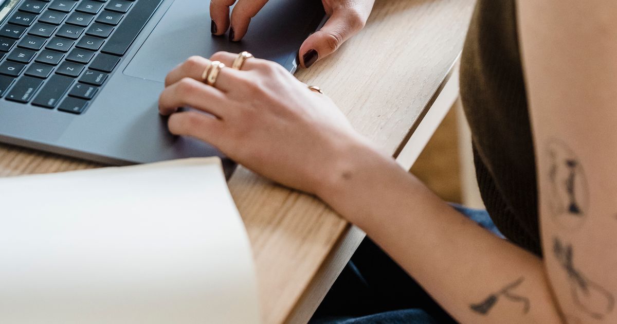 Manos revisando la nómina con una calculadora en el escritorio